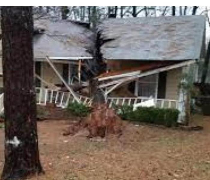 Photo of the outside of a home after storms rolled through our area. You can see where the tree fell on the roof. 