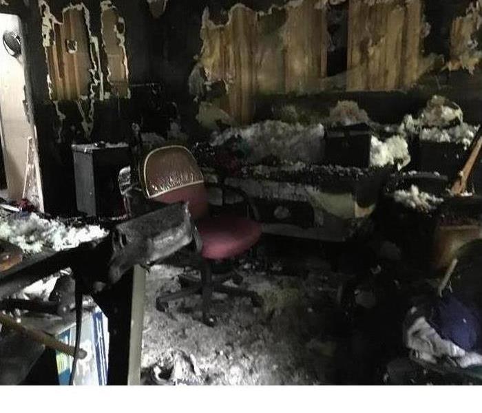 This is a photo of a room where a fire started in a home. You can kind of make out the furniture and where things were placed